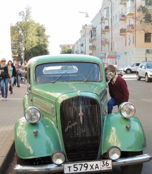 A boy scrutinize cabin of the retro car