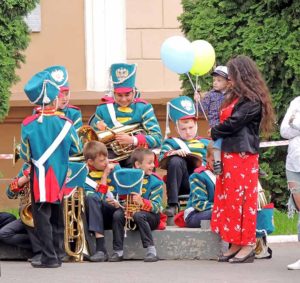 Participants of children's brass band dressed in uniforms in the style of the Russian Army at the XIX century's beginning waiting for their performance.
